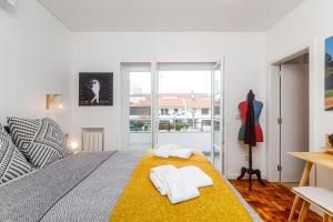 Augusto - your family house in the heart of Lisbon في لشبونة: غرفة نوم عليها سرير وفوط