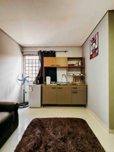 a kitchen with a couch and a refrigerator in a room at Apartamento ótima localização in Passo Fundo