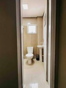 a bathroom with a white toilet and a sink at Apartamento ótima localização in Passo Fundo