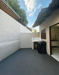 a white building with a desk and a staircase at Casa privativa próximo ao centro e aeroporto. in Campo Grande