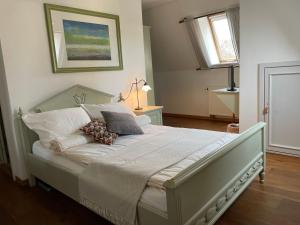 a bedroom with a large bed with white sheets and pillows at Hotel zur Schlossmühle in Borna