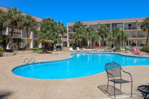 a pool in front of a building with chairs in it at NEW-The Villas-Pool-BBQ-Casino-Colosseum-Beach-Tennis Courts in Biloxi