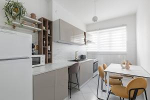 a white kitchen with a table and chairs at Apartment Resorts Place in Split