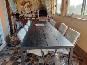 a dining room table with white chairs and a fireplace at Apartments Rajka in Lopar