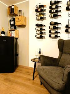 um quarto com um sofá e uma prateleira de garrafas de vinho em Bricco Nebbiolo em Neviglie