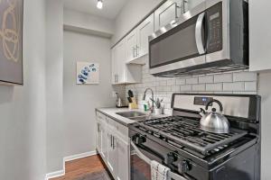a kitchen with a stove with a tea kettle at Modern Chic 1BR in Downtown Chicago - Dorchester 204 in Chicago