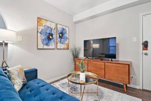 a living room with a blue couch and a tv at Modern Chic 1BR in Downtown Chicago - Dorchester 204 in Chicago