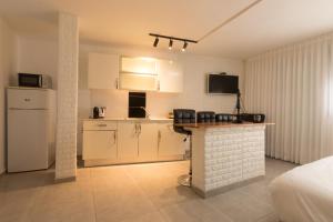 a kitchen with white cabinets and a counter in a room at Sweet Dreams Apartment in Tiberias
