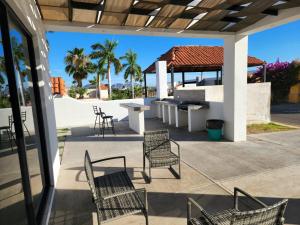 a patio with chairs and a table and a grill at Casa Espaciosa Alberca Privada En fraccionamiento Country Club de Golf in San Carlos