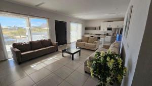 uma sala de estar com sofás e uma mesa e uma cozinha em Casa Espaciosa Alberca Privada En fraccionamiento Country Club de Golf em San Carlos