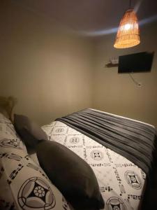 ein Schlafzimmer mit einem Bett mit Kissen und einer Lampe in der Unterkunft Chalé D'maré in São Miguel dos Milagres