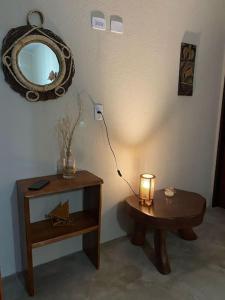 a room with a table and a mirror and a lamp at Chalé D'maré in São Miguel dos Milagres