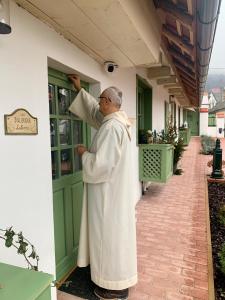 a man in a white robe standing outside a building at Pannonhalma Várlak Vendégház in Pannonhalma