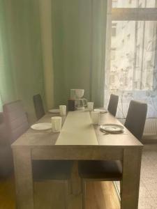 a dining room table with chairs and a large window at Stilvolles Zuhause in Magdeburg