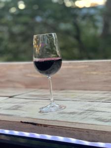 a glass of red wine sitting on a table at Calafate lodge patagonia in Coihaique