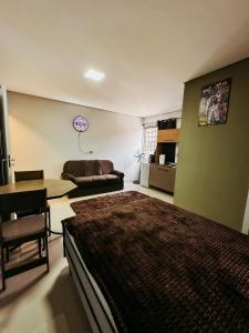 um quarto com uma cama e uma sala de estar em Apartamento ótima localização em Passo Fundo