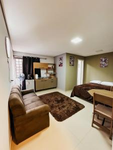 - un salon avec un canapé et un lit dans l'établissement Apartamento ótima localização, à Passo Fundo