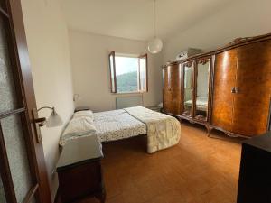 a bedroom with a bed and a large wooden cabinet at Casa in campagna: Completo Relax in Albissola Marina