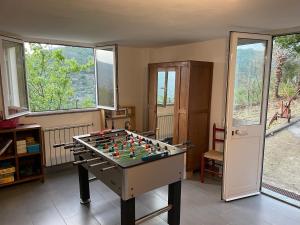 a room with a foosball table in a room with windows at Casa in campagna: Completo Relax in Albissola Marina