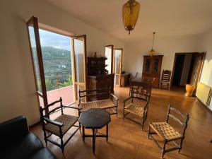 a living room with chairs and a table and a window at Casa in campagna: Completo Relax in Albissola Marina