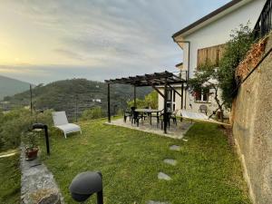 a backyard with a table and chairs and a pergola at Casa in campagna: Completo Relax in Albissola Marina