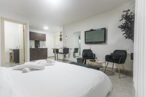 a bedroom with a white bed and a flat screen tv at Sweet Dreams Apartment in Tiberias