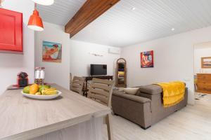 a living room with a table and a couch at Villa Lodge - Bas de Villa avec piscine et vue océan et Moorea in Punaauia