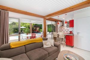 un soggiorno con divano e una cucina di Villa Lodge - Bas de Villa avec piscine et vue océan et Moorea a Punaauia