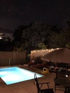 a swimming pool in a backyard at night at Roca de Guía. Casa con piscina y barbacoa cerca del mar in Punta del Este