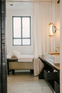 uma casa de banho com uma banheira, um lavatório e uma janela em Hotel Matilda em San Miguel de Allende
