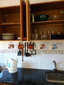 a kitchen counter with a sink and utensils at Roca de Guía. Casa con piscina y barbacoa cerca del mar in Punta del Este