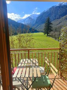 a balcony with a table and a view of a field at Ventana al Paraíso del Oso - Somiedo. Window to Bear Paradise - Somiedo in Pola de Somiedo