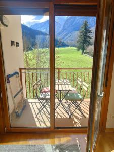 a patio with a table and chairs on a balcony at Ventana al Paraíso del Oso - Somiedo. Window to Bear Paradise - Somiedo in Pola de Somiedo