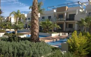 una villa con piscina y palmeras en Zenia Beach, en Orihuela