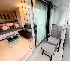 Habitación pequeña con silla y balcón. en Skyline suite 2, en Oostduinkerke