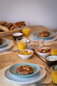 una mesa con platos de comida y vasos de zumo de naranja en Buitenlede 7 - Suite M, en Dwingeloo