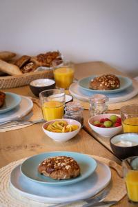 een tafel met borden en glazen sinaasappelsap bij Buitenlede 7 - Suite M in Dwingeloo