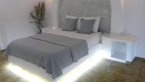 ein weißes Schlafzimmer mit einem Bett mit Licht in der Unterkunft Apartments & Suites Papafotis in Alinda