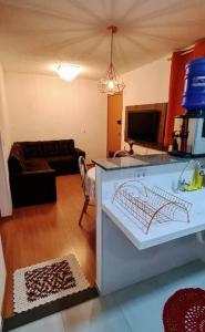 uma sala de estar com uma cozinha e uma sala de estar com um sofá em Apartamento completo, privativo, ótima localização (Próximo ao Aeroporto) em Campo Grande