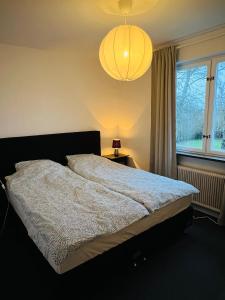 1 dormitorio con 1 cama grande y lámpara de araña en Casa 716 - Villa nära golf & natur en Bara