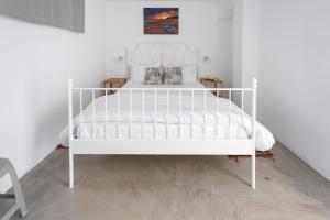 a white bed in a room with a white bed frame at Ikiesnafplio in Nafplio