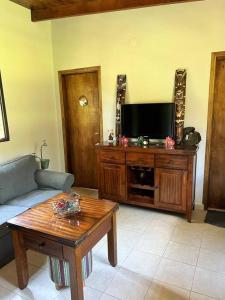 a living room with a couch and a flat screen tv at Cabaña “La Herencia” Paraguarí in Paraguarí