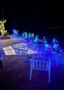 een groep stoelen en een tafel met kerstverlichting bij Cabaña “La Herencia” Paraguarí in Paraguarí