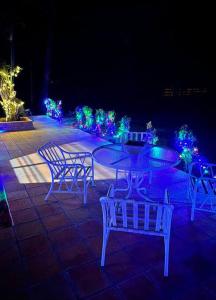 a group of chairs and a table with christmas lights at Cabaña “La Herencia” Paraguarí in Paraguarí