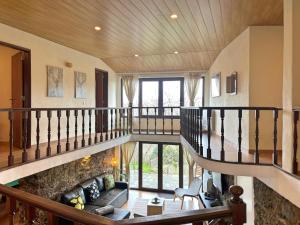 un grand salon avec un escalier et un canapé dans l'établissement Retiro de Gondramaz - Whole house, Casa inteira 200 m2, à Gondramaz