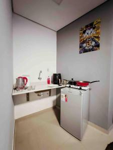 eine kleine Küche mit einem Kühlschrank und einer Theke in der Unterkunft Studio próximo Aeroporto e UPF in Passo Fundo