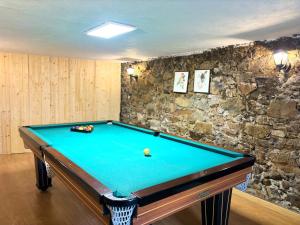 una mesa de billar en una habitación con una pared de piedra en Retiro de Gondramaz - Whole house, Casa inteira 200 m2, en Gondramaz