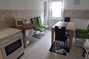 a kitchen with green chairs and a table and a stove at OCTOPUS 2-ZKB 2.OG Hofgeismar-Zentrum! in Hofgeismar