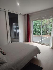 1 dormitorio con cama y ventana grande en Charmante maison près du Futuroscope en Saint-Georges-lès-Baillargeaux