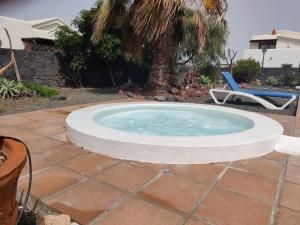 een klein zwembad met een stoel in een tuin bij Villa Marina Deluxe & Spa Pool in Playa Blanca